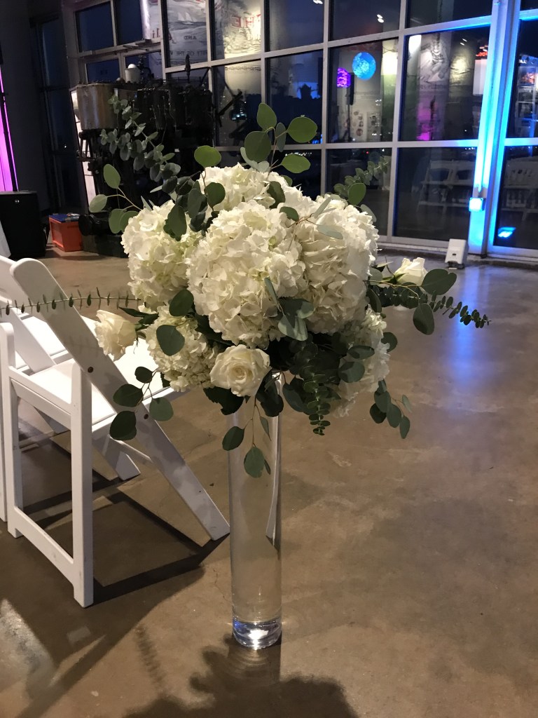 $121 - tall white and green reception centerpiece repurposed in aisle