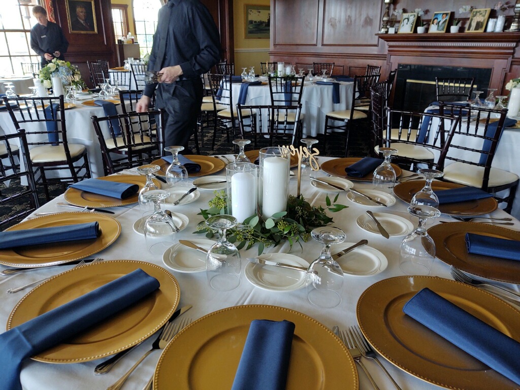 two rented white pillar candles in 7" and 10" cylinder with loose greenery